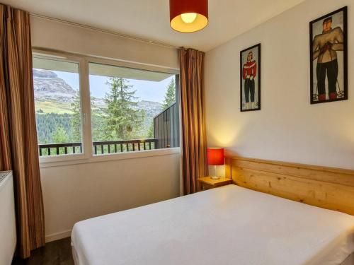 sypialnia z łóżkiem i dużym oknem w obiekcie Appartement lumineux avec balcon sud, centre station, parking couvert - Flaine Forêt - FR-1-425-141 w mieście Flaine