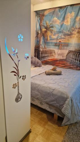 a bedroom with a bed with a painting on the wall at Pikku Kodikas koti in Lapua