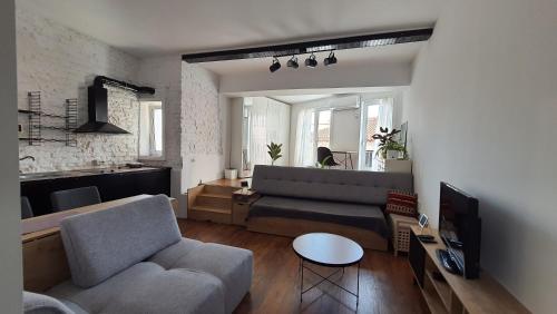 una sala de estar con un sofá y una mesa en Duo Apartment Durres Center, en Durrës