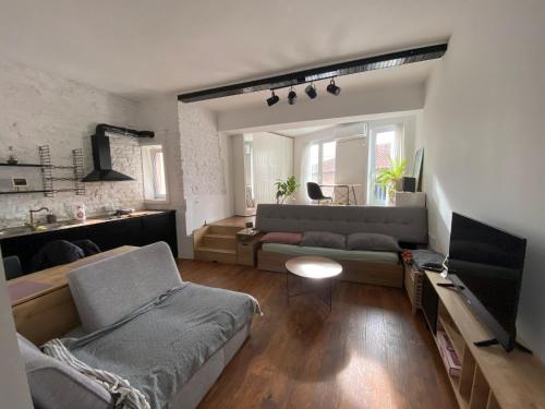 Una sala de estar con un sofá y un televisor. en Duo Apartment Durres Center, en Durrës