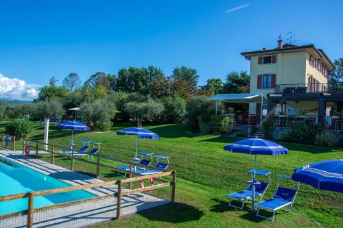 a group of chairs and umbrellas next to a pool at Agriturismo Il Giardino Degli Ulivi in Lazise
