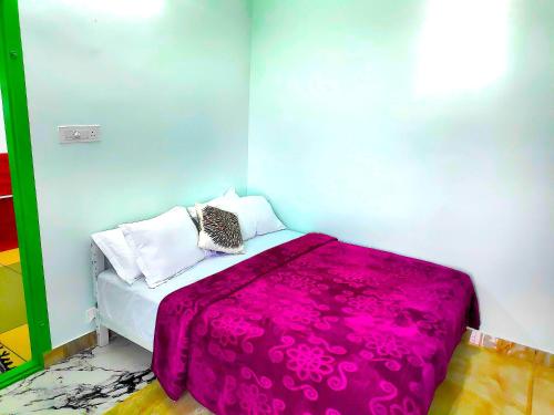 a bedroom with a bed with a pink blanket at M C Greenature Holidays in Pooppara
