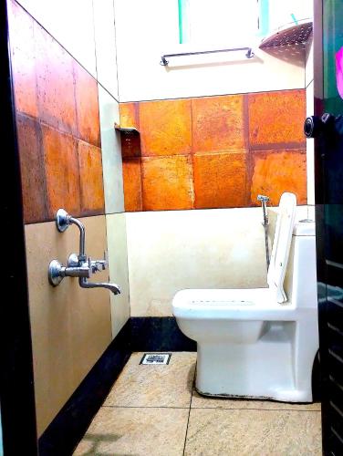 a bathroom with a white toilet in a stall at M C Greenature Holidays in Pooppara
