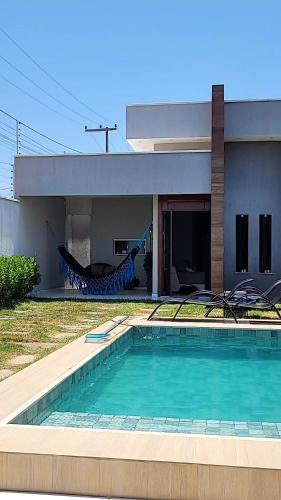 a house with a swimming pool in front of a house at Casa de Praia em Beberibe - House 4k Beberibe, Acomoda até 12 pessoas in Beberibe