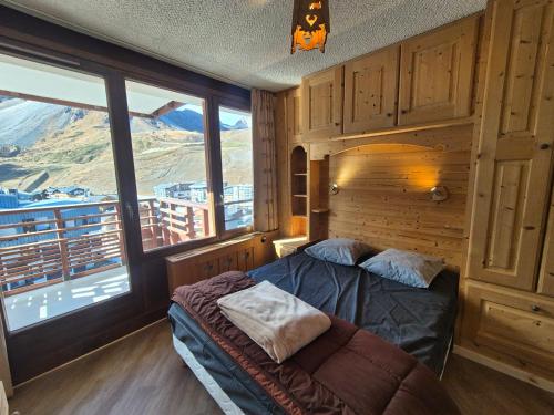 une chambre avec un lit et une grande fenêtre dans l'établissement Appartement lumineux proche pistes et commerces, 3P/8 pers, balcon exposé sud - FR-1-502-363, à Tignes