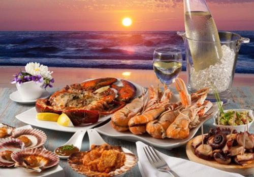 a table with plates of food and a view of the ocean at Bungalows Beach Key West - Azucar in Key West