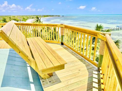 a wooden bench sitting on a balcony overlooking the ocean at Bungalows Beach Key West - Azucar in Key West