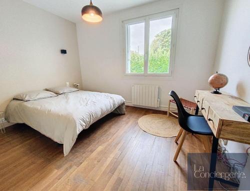 a bedroom with a bed and a desk and a window at Beausoleil - Futuroscope - LaConciergerie in Chasseneuil-du-Poitou