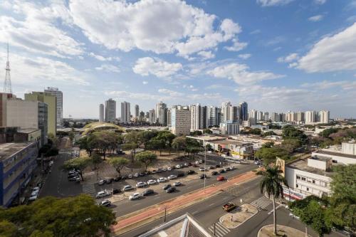 a city with cars parked in a parking lot at Excelente Espaço Centro CA904 in Maringá