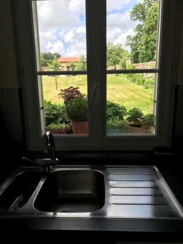 d'un évier de cuisine et d'une fenêtre avec vue sur la cour. dans l'établissement Domaine de Gretot, à Hugleville-en-Caux