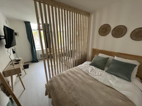 En eller flere senge i et værelse på Le Cocon Naturel - Studio 2p Ville fortifiee