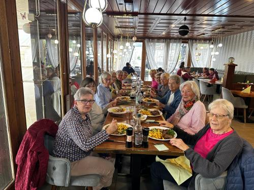 a group of people sitting at a table eating food at Buffet de la gare Courtelary in Courtelary
