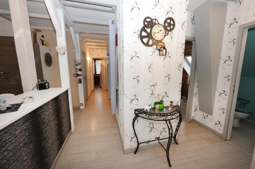 einen Flur mit einem Tisch und einer Uhr an der Wand in der Unterkunft Le clocher aux cigognes au village de Bergheim in Bergheim