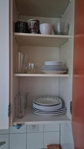 a cupboard filled with plates and bowls and dishes at Pikku Kodikas koti in Lapua