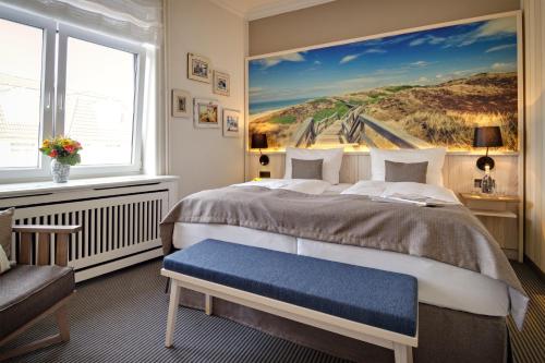 a bedroom with a bed with a painting on the wall at Sylter Domizil in Wenningstedt