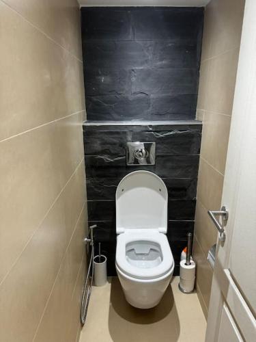 a small bathroom with a toilet with black walls at Villa Brussel in Dilbeek