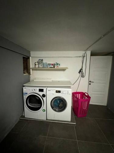a washing machine in a laundry room with a basket at Villa Brussel in Dilbeek