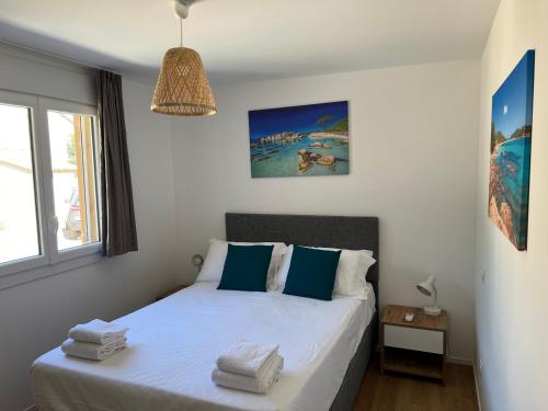 - une chambre avec un lit doté de draps blancs et d'oreillers bleus dans l'établissement Cala Rossa T2 Neuf à 800 m de la mer appart n 81, à Lecci