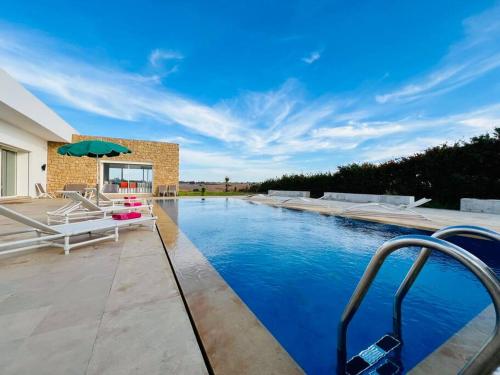 a swimming pool in the middle of a house at Riverside 3BR Farm - Pool & Stunning Views in Oulad Yakoub
