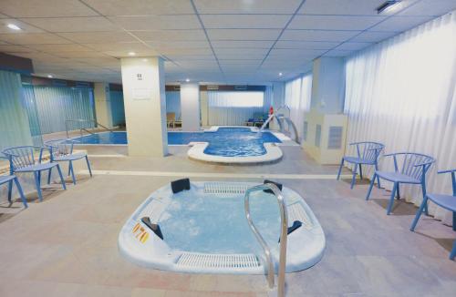 a large hot tub in a room with chairs and tables at Eurosalou & Spa in Salou