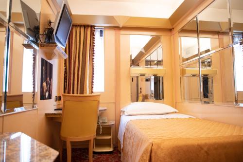 a bedroom with a bed and a desk and a tv at Hotel Wagner in Milan