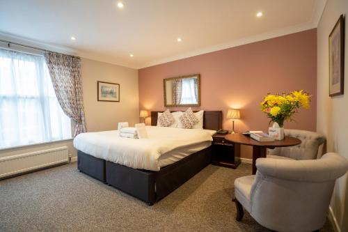 a bedroom with a bed and a desk and a chair at Marlborough House - Guest House in Oxford