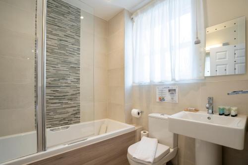 a bathroom with a toilet and a sink and a shower at Marlborough House - Guest House in Oxford