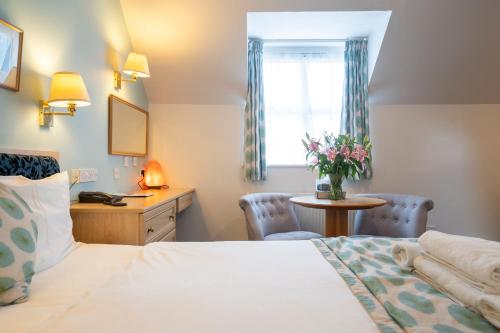 a hotel room with a bed and a table and a window at Marlborough House - Guest House in Oxford