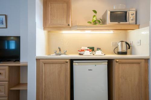 a kitchen with a white refrigerator and a microwave at Marlborough House - Guest House in Oxford
