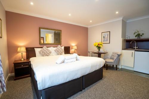 a bedroom with a large bed and a kitchen at Marlborough House - Guest House in Oxford