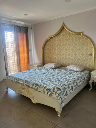 - une chambre dotée d'un grand lit avec un cadre en or dans l'établissement Soniaedmon, à Perpignan