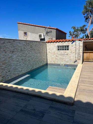 - une piscine en face d'un mur de briques dans l'établissement Soniaedmon, à Perpignan
