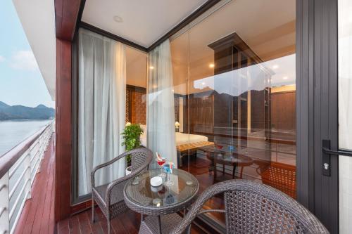 a balcony with a table and chairs on a cruise ship at Aqua Of The Seas Cruise Halong in Ha Long