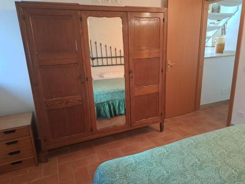 a bedroom with a large wooden cabinet with a mirror at Villa Azul Bocale in Pellaro