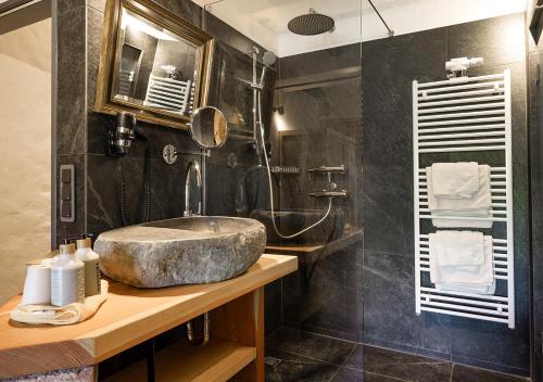 a bathroom with a stone sink and a shower at Hotel Land Gut Höhne in Mettmann