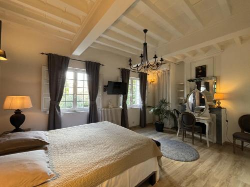 a bedroom with a bed and a desk and a chair at hôtel particulier d'hôte le Philippe-le-Bel in Villeneuve-lès-Avignon