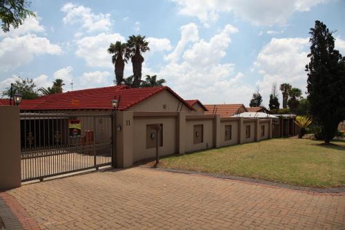 a building with a gate and a fence at Guest Home KS2E - Self Catering in Kempton Park
