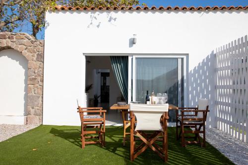 アイギナにあるKyma Aegina Suitesのパティオ(芝生の上にテーブルと椅子付)