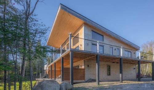 a house with a wooden facade at Chalet TIPI, Chic Charme & Nature in La Malbaie