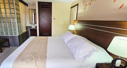 a bedroom with a large bed with a wooden headboard at Hotel Tungurahua in Baños