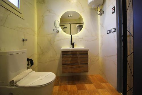 a bathroom with a toilet and a mirror at Palm Pyramid View Inn in Cairo