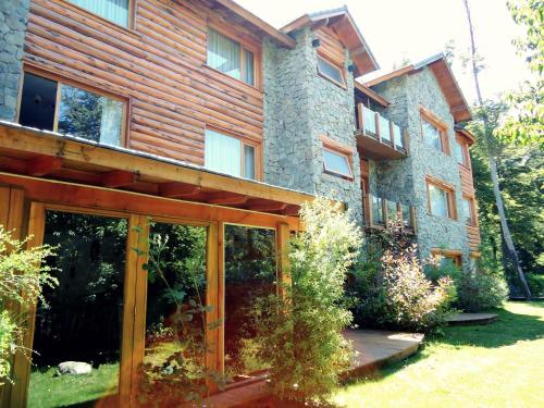 a house with glass doors in front of it at Hosteria Patagon in Villa La Angostura