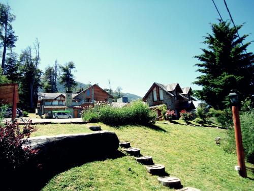 a yard with a house and a house with a pathway at Hosteria Patagon in Villa La Angostura