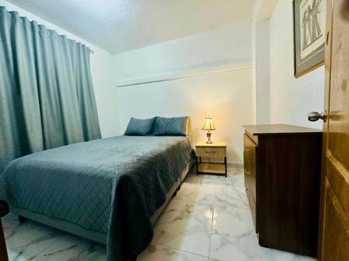 a bedroom with a bed and a dresser and a television at Welcome Home in Bogotá