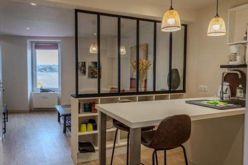 une cuisine avec une table et des chaises dans une pièce dans l'établissement Ti Gwer - vue mer - wifi, à Crozon