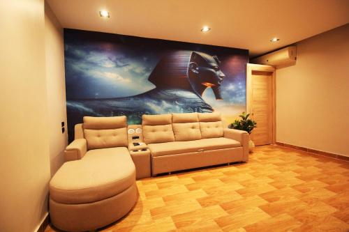 a living room with a couch and a painting at Palm Pyramid View Inn in Cairo