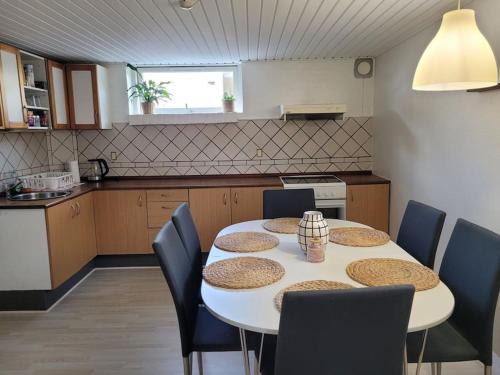 a kitchen with a white table and chairs and a kitchen with a table and chairs at Cozy basement apartment in the center in Hirtshals