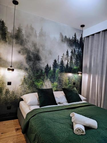 a bedroom with a bed with a painting on the wall at Apartament w Bartoszycach in Bartoszyce