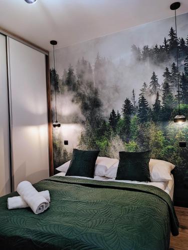 a bedroom with a bed with a painting on the wall at Apartament w Bartoszycach in Bartoszyce