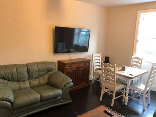 a living room with a couch and a table with chairs at 4 Bedroom Flat in Centre of Shifnal in Shifnal